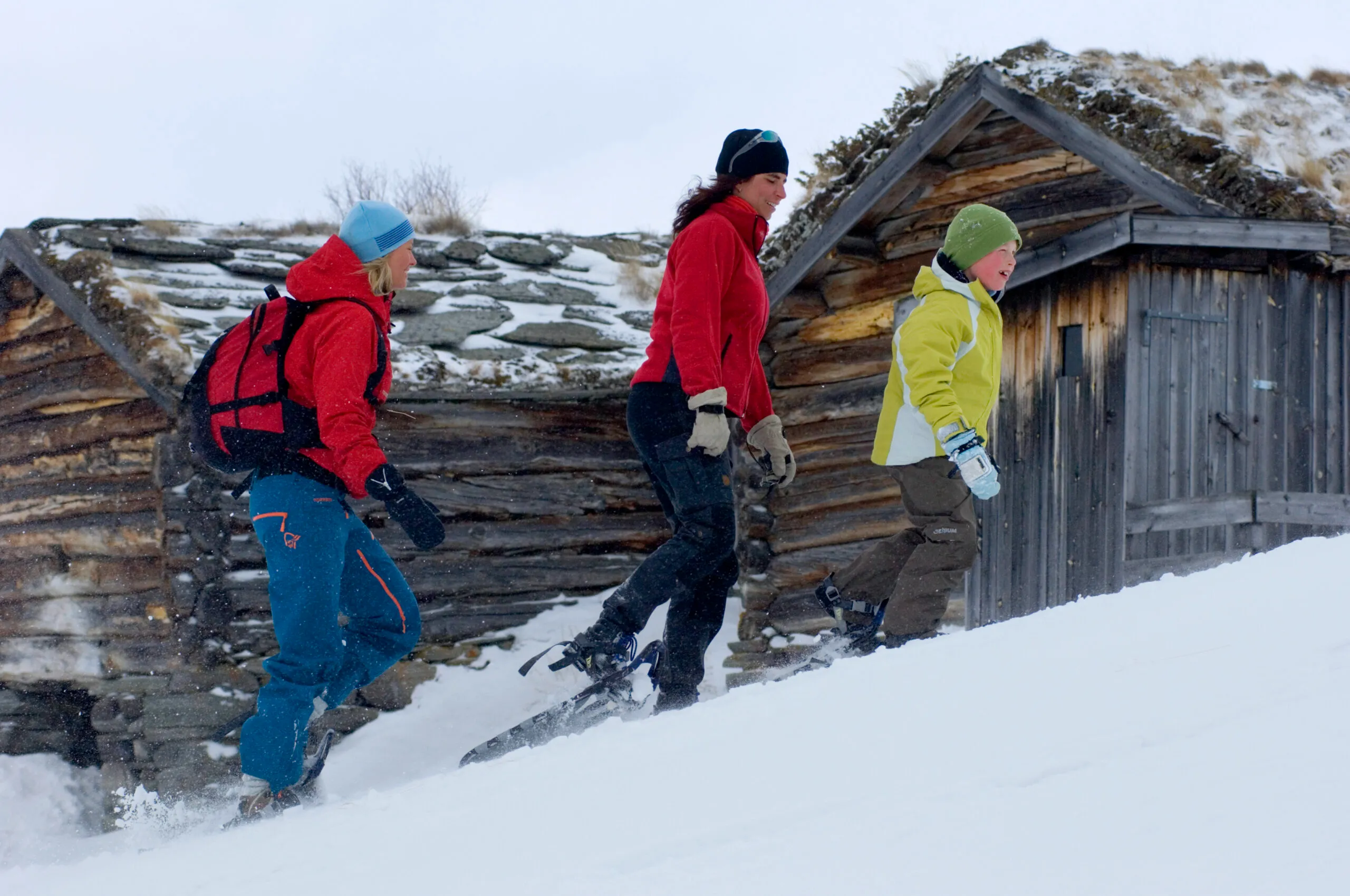 Three people snowshoeing through the snowy landscapes of Norway.