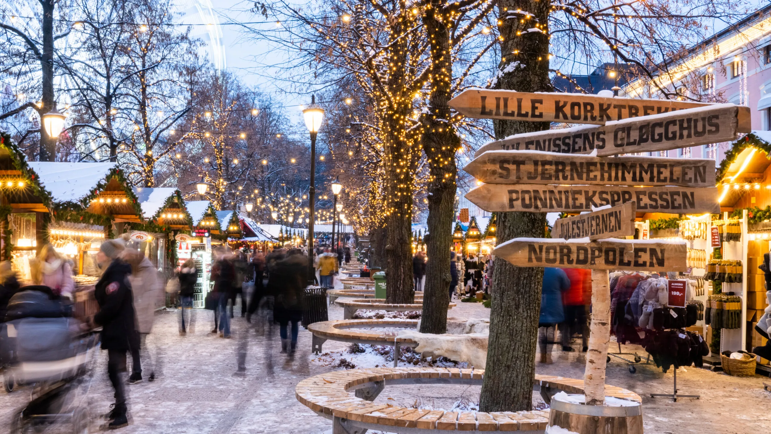 A festive Christmas market in Oslo, with colorful lights, holiday decorations, and bustling stalls offering seasonal treats and gifts.