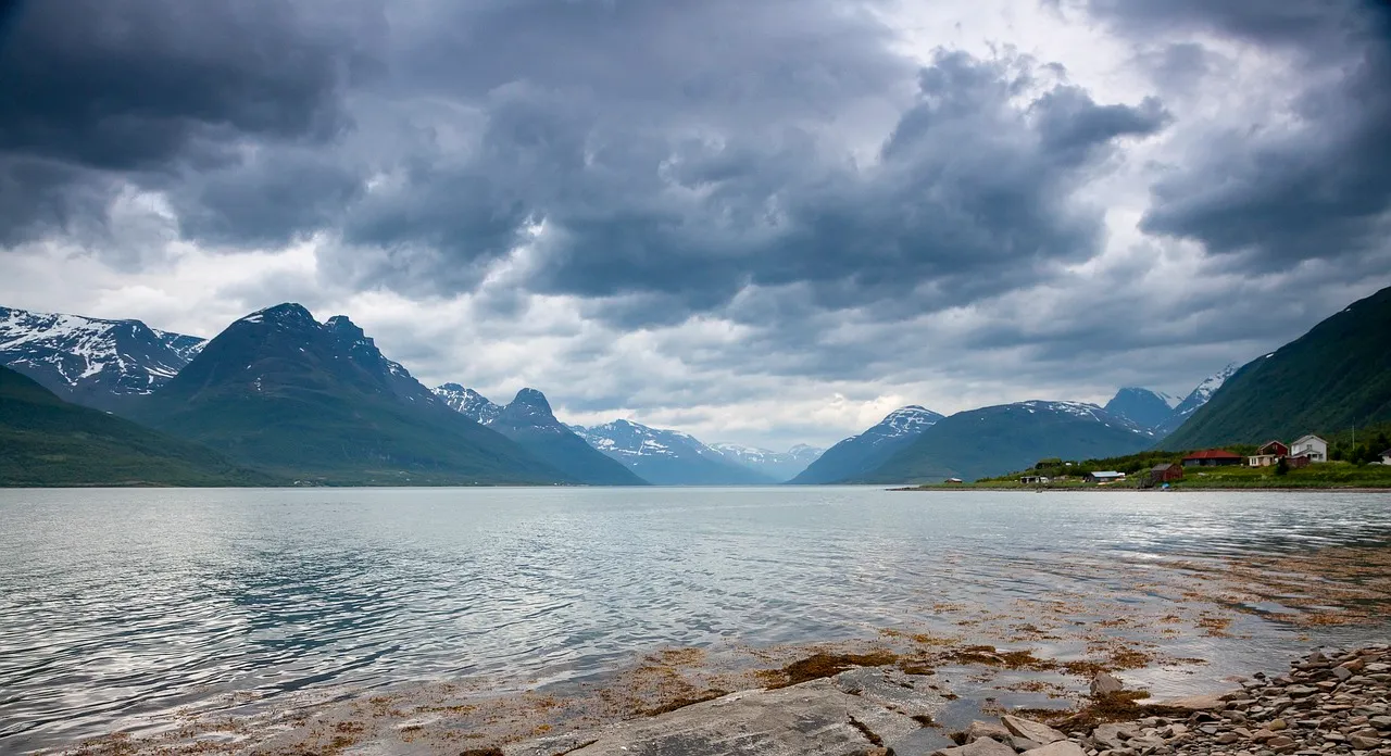 Panoramic view of Lyngen, Norway, featuring a majestic mountain range, serene fjords, and picturesque villages, showcasing the region's breathtaking natural beauty.